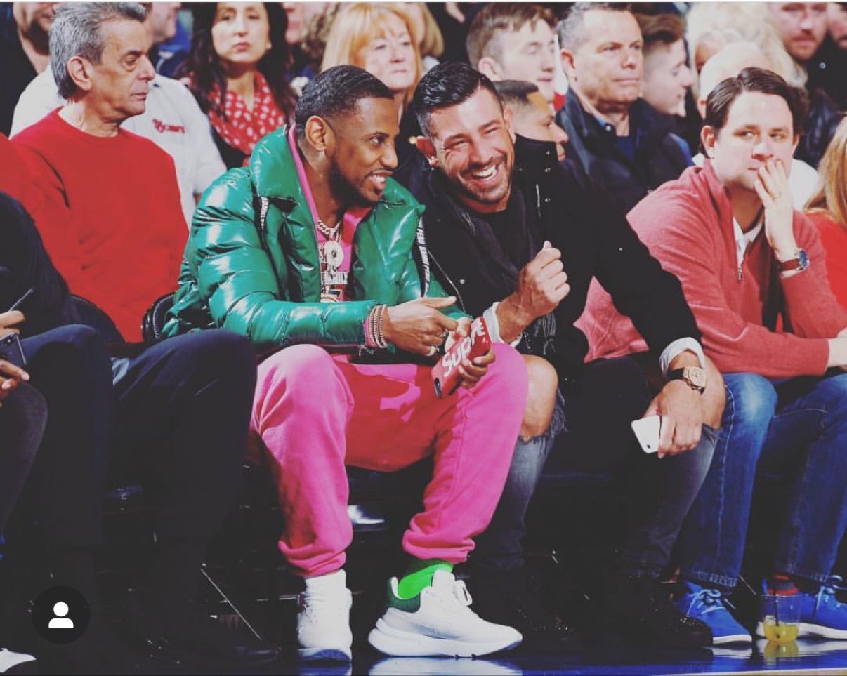 Richie Hosein sitting courtside with rapper Fabolous at the St. John's game at Madison Square Garden